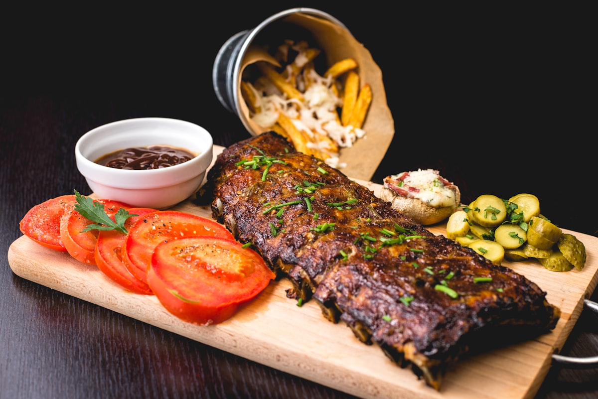 BBQ Ribs mit Beilagen auf Holzbrett